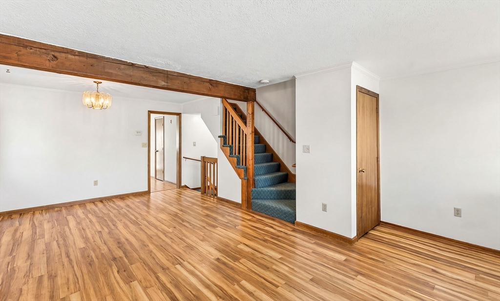 61 Fox Meadow Road, Unit A Leominster, MA 01453 - Photo 3 of 38 a view of an empty room with wooden floor and stairs