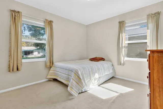 a bed sitting in a bedroom next to a window
