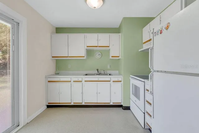 a utility room with cabinets washer and dryer