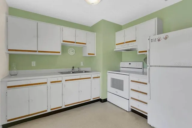 a kitchen with cabinets appliances and a sink