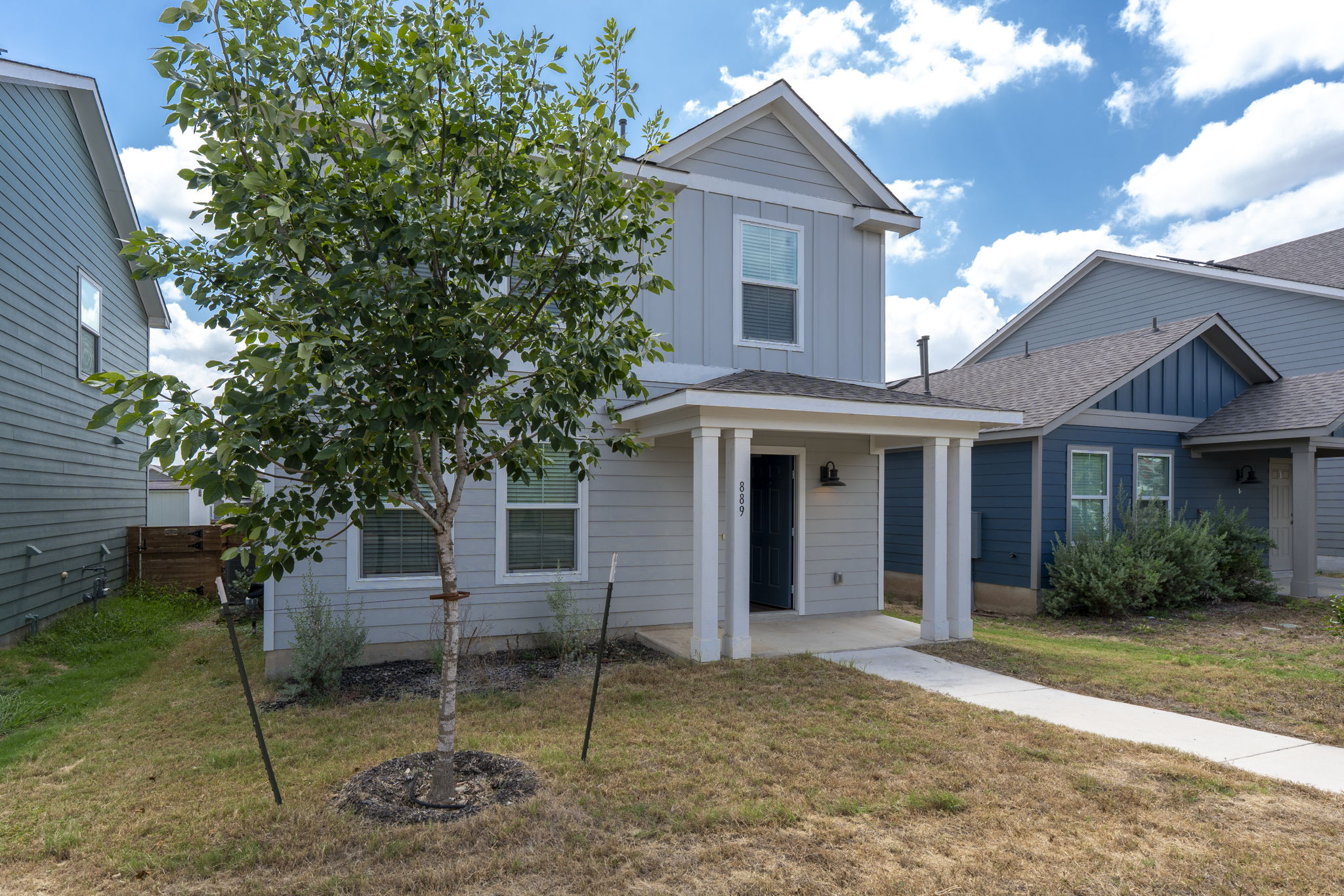 889 Powell Kyle, TX 78640 - Photo 3 of 22 A welcoming front porch with classic columns accents the modern board and batten siding.