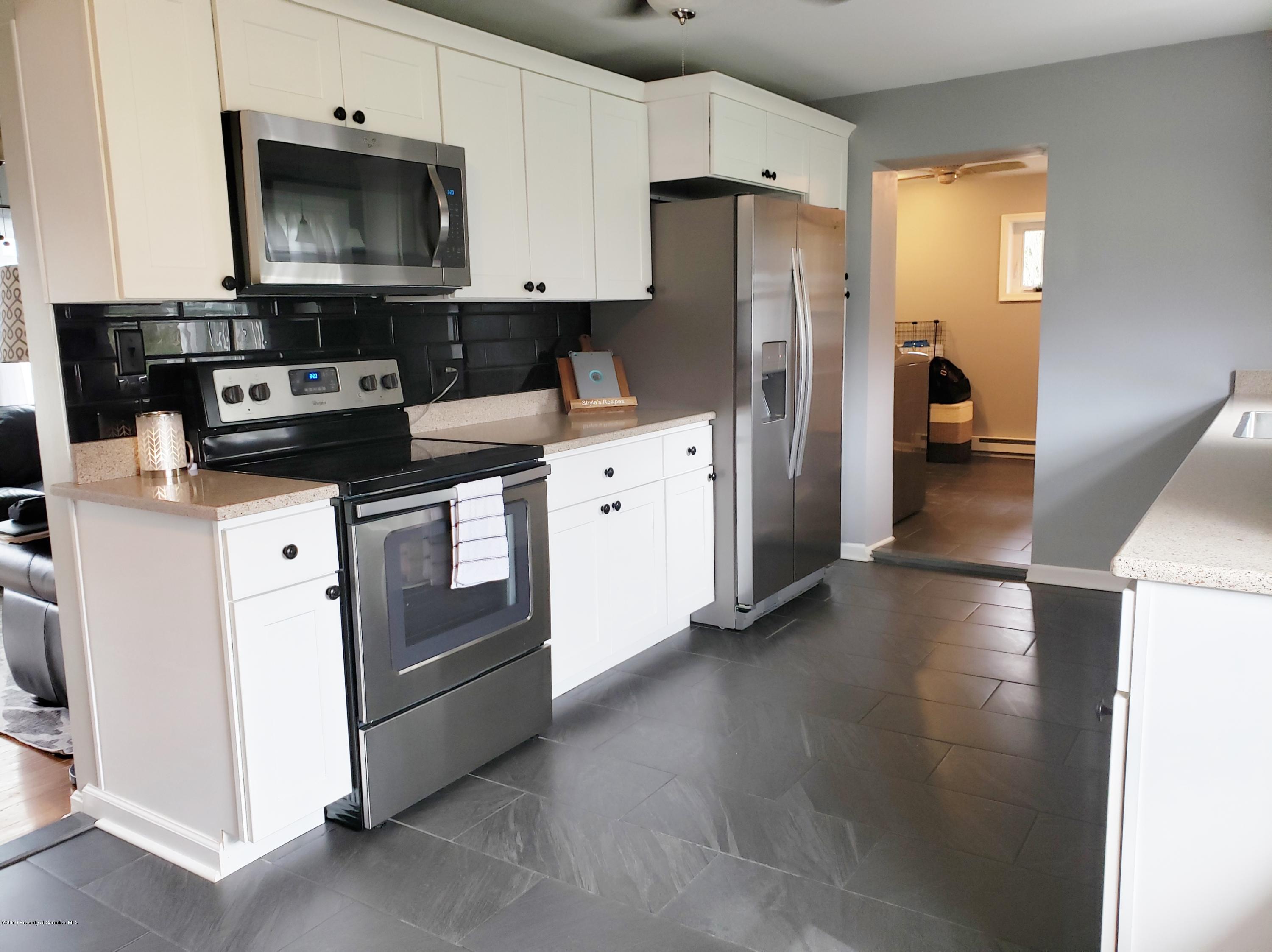 1816 Green Ridge Street Dunmore, PA 18509 - Photo 6 of 30 a kitchen with stainless steel appliances a stove a refrigerator a sink a stove and cabinets