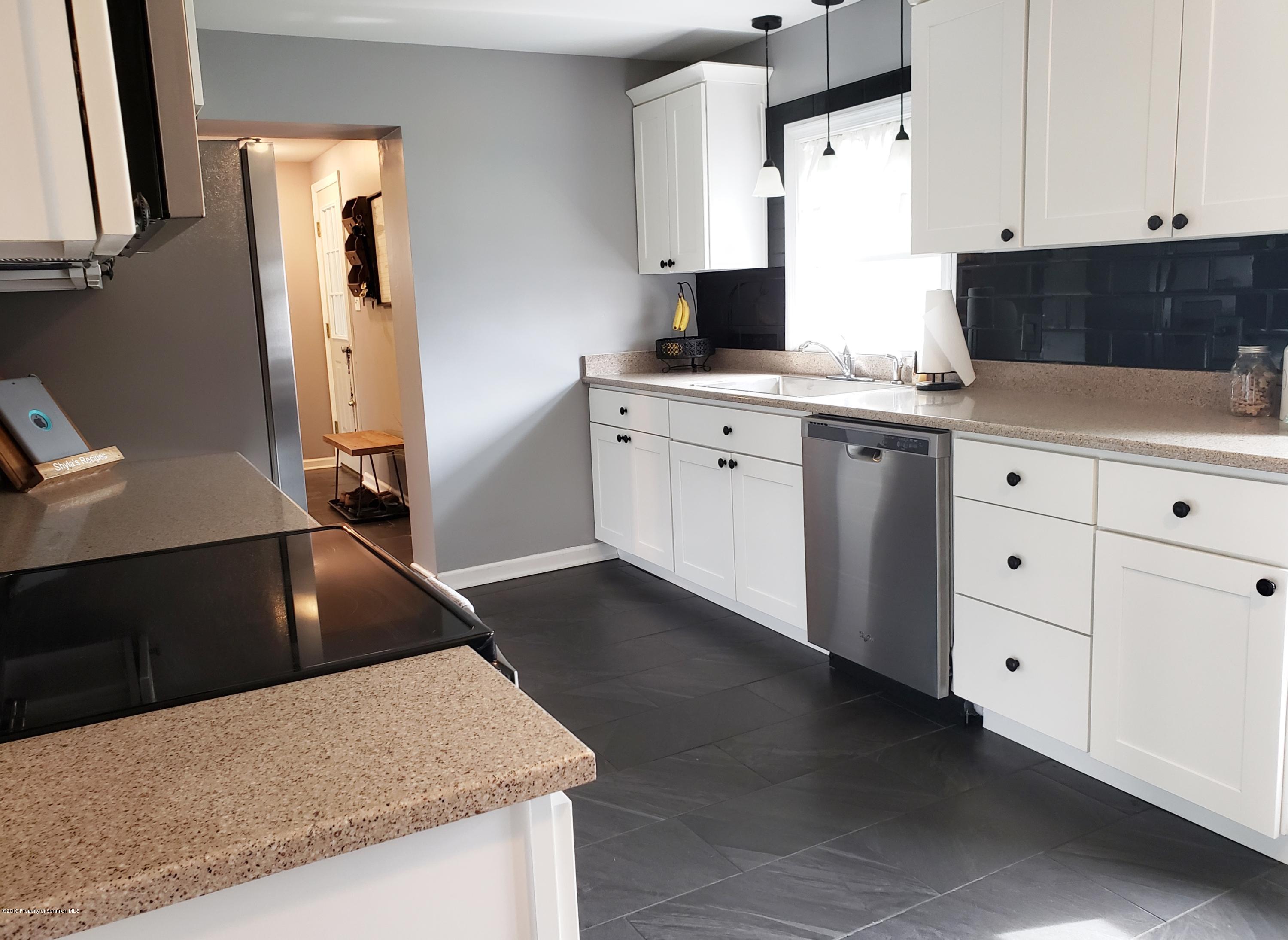 1816 Green Ridge Street Dunmore, PA 18509 - Photo 7 of 30 a kitchen with granite countertop a sink a stove and cabinets