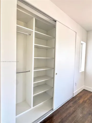 a view of walk in closet with empty racks