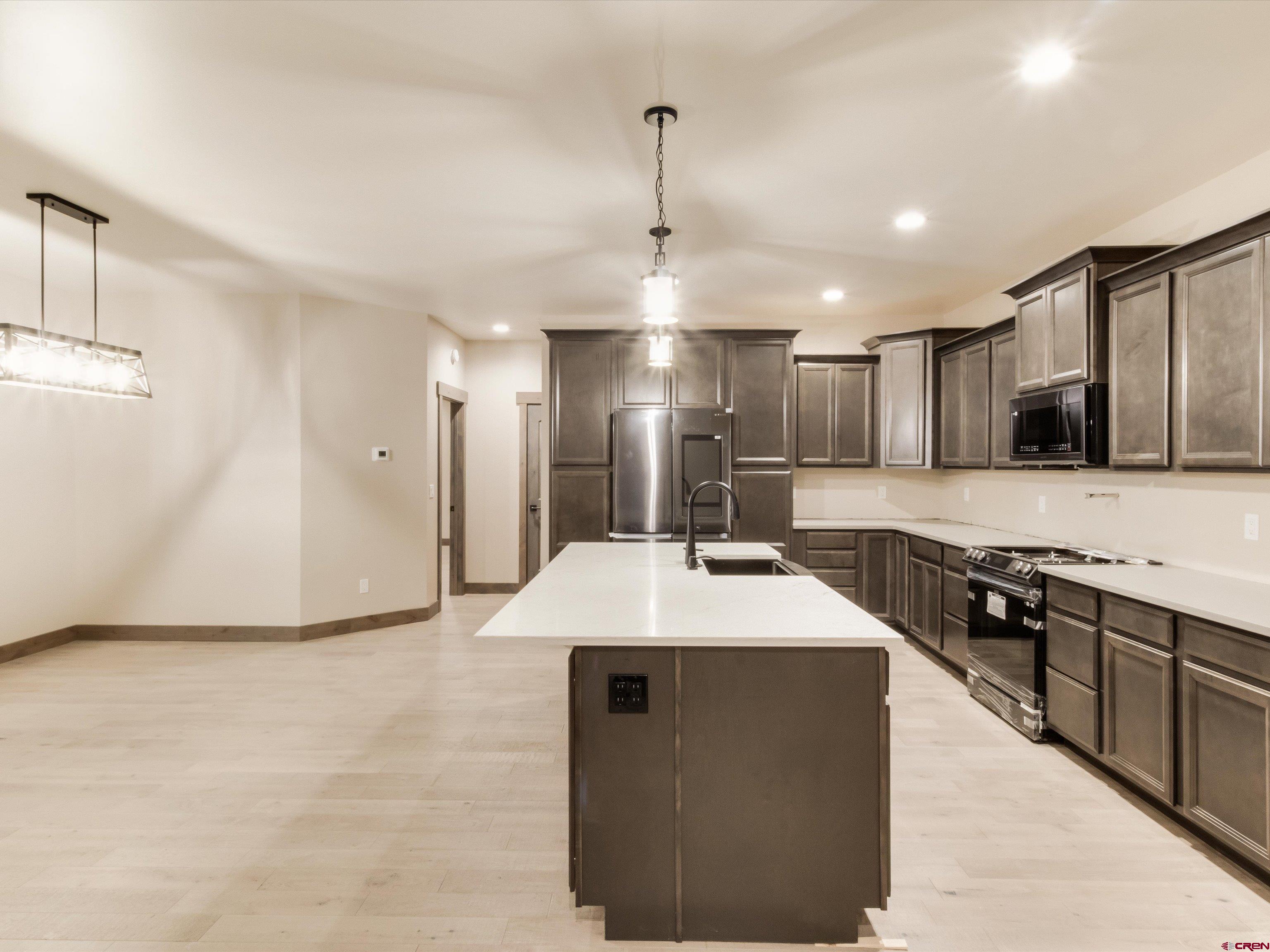 1900 Snaffle Bit Road Delta, CO 81416 - Photo 11 of 33 a large kitchen with stainless steel appliances kitchen island granite countertop a stove a sink a refrigerator and a cabinets