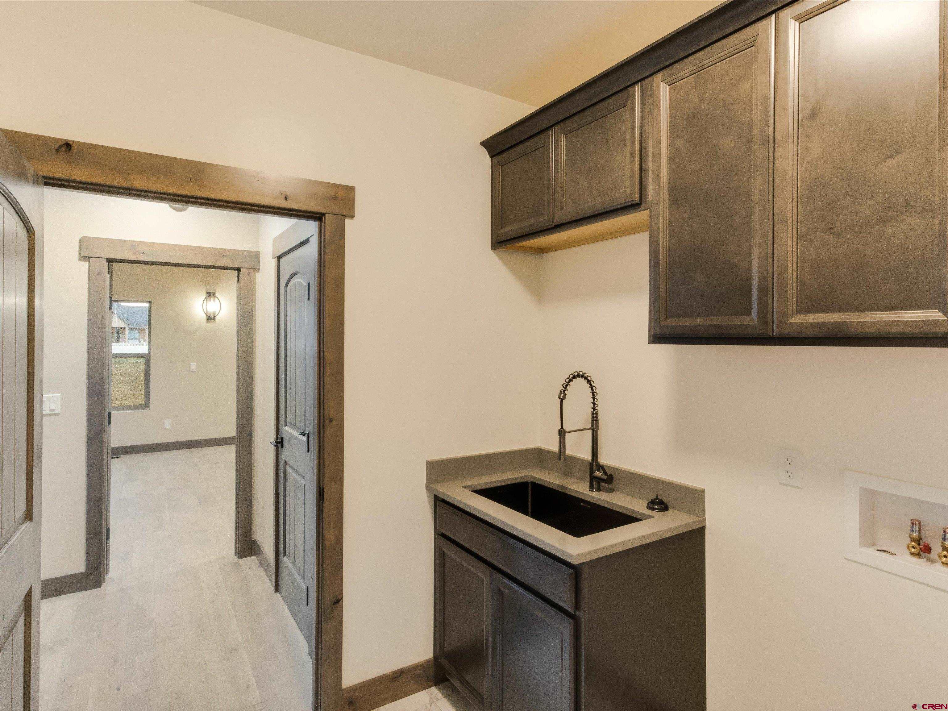 1900 Snaffle Bit Road Delta, CO 81416 - Photo 21 of 33 a kitchen with a sink a refrigerator and cabinets