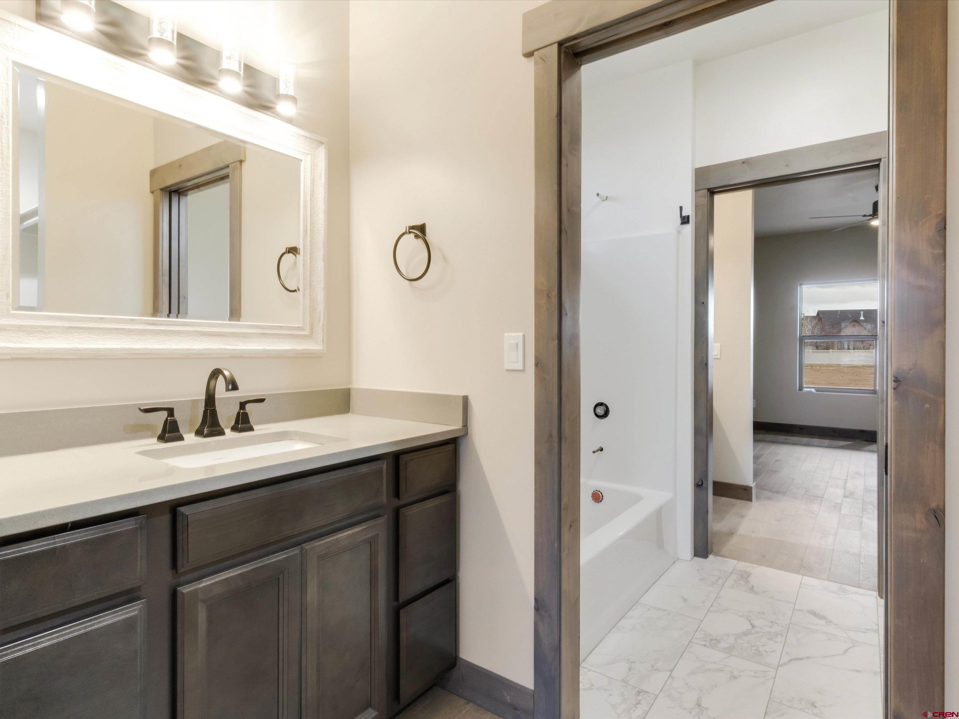 1900 Snaffle Bit Road Delta, CO 81416 - Photo 26 of 33 a en suite bathroom with a granite countertop sink and a mirror