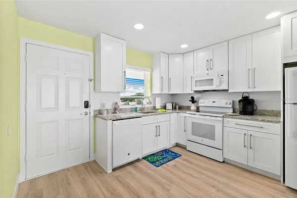 a kitchen with granite countertop a sink a stove and cabinets