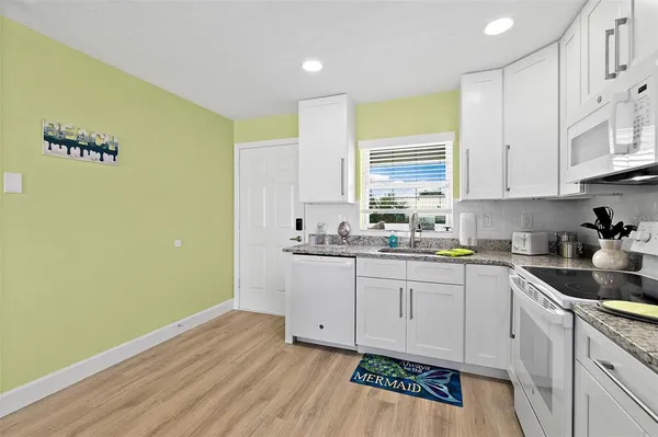 a kitchen with cabinets stainless steel appliances and a window
