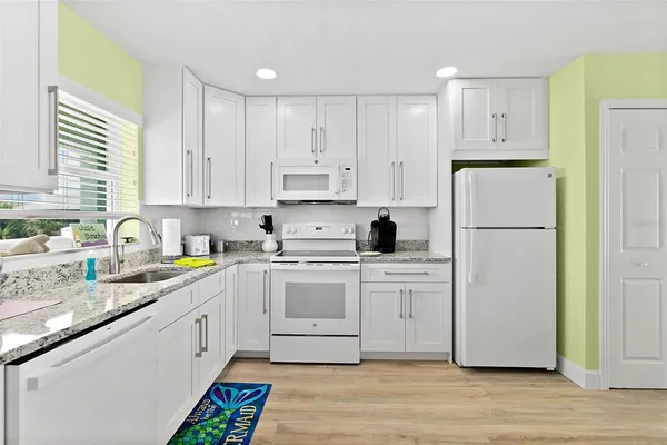 a kitchen with white cabinets and stainless steel appliances