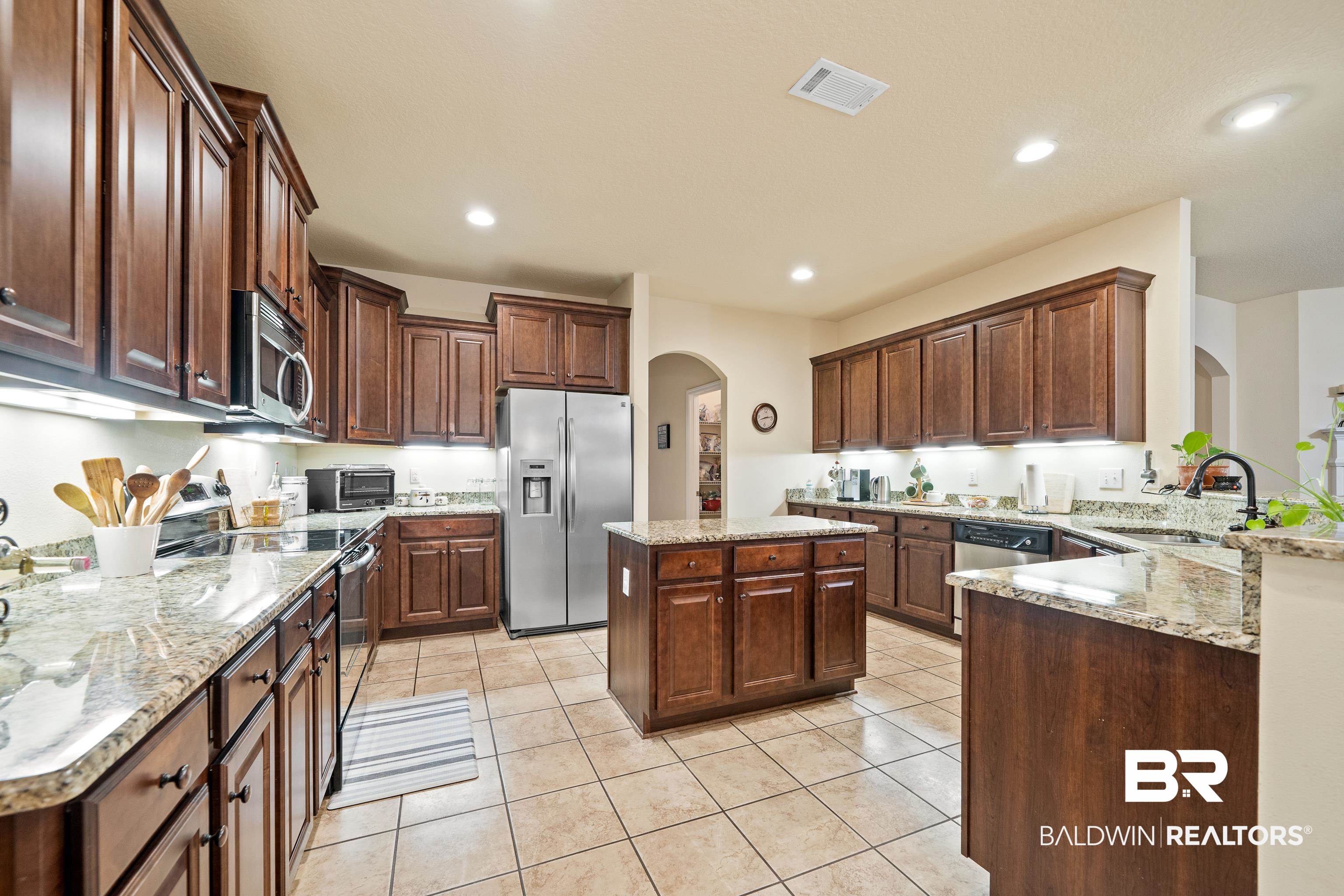 9115 Krystal Ridge Court Daphne, AL 36526 - Photo 10 of 39 Kitchen featuring light tile patterned flooring, sink, appliances with stainless steel finishes, a kitchen island, and kitchen peninsula