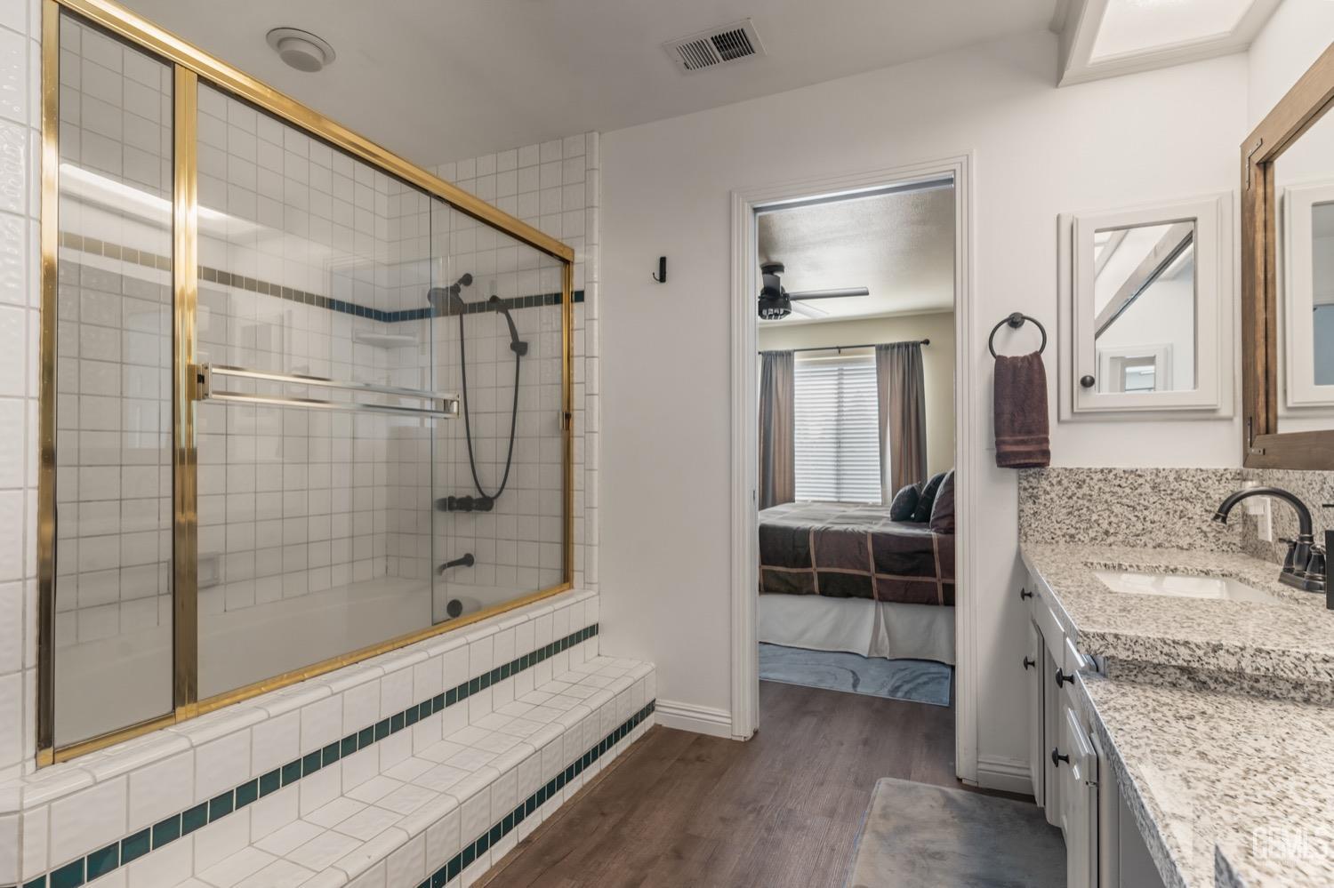 Undisclosed Address Bakersfield, CA 93312 - Photo 20 of 29 a bathroom with a granite countertop sink a mirror and shower
