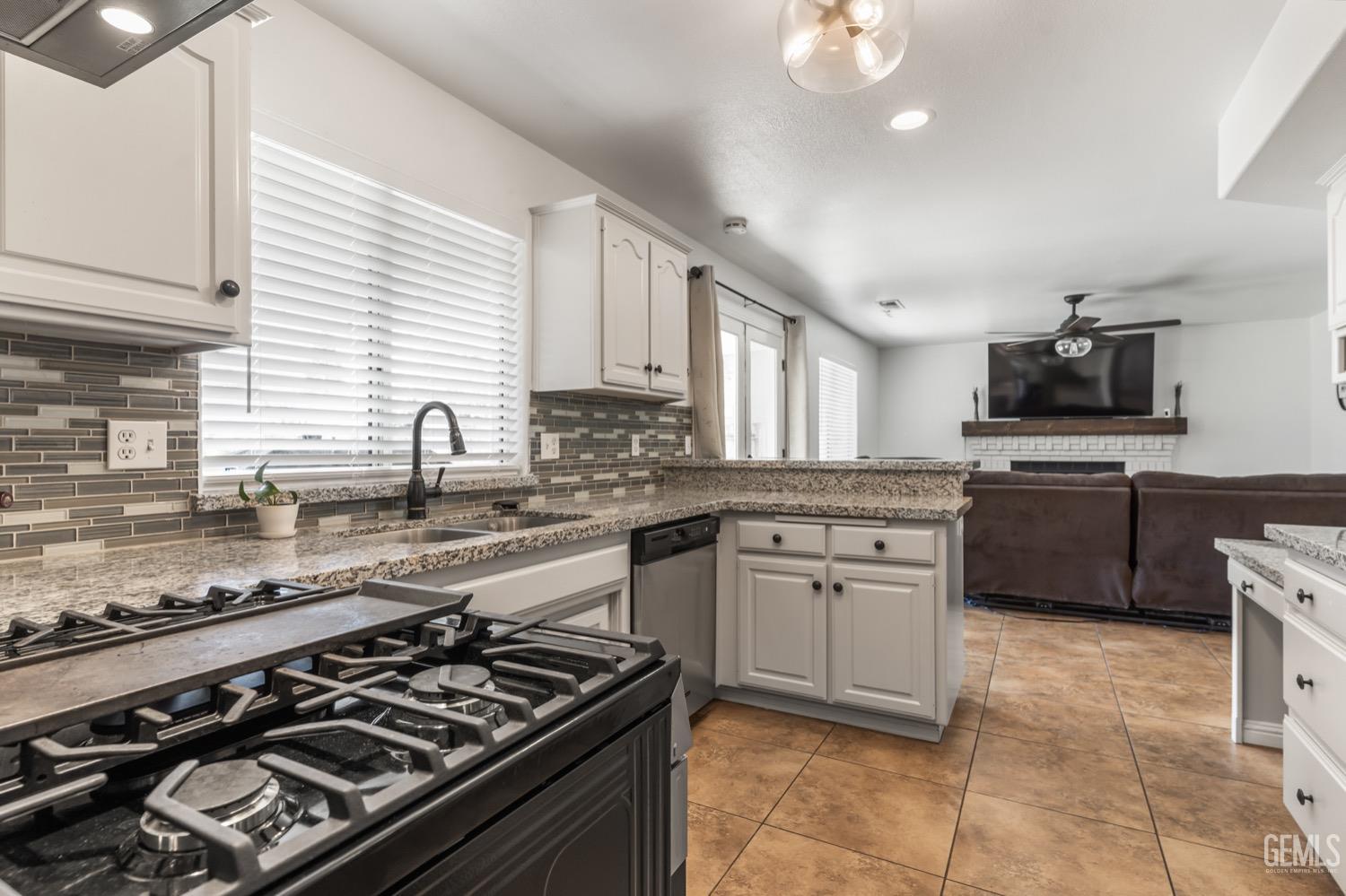 Undisclosed Address Bakersfield, CA 93312 - Photo 6 of 29 a kitchen with a stove a sink and a microwave
