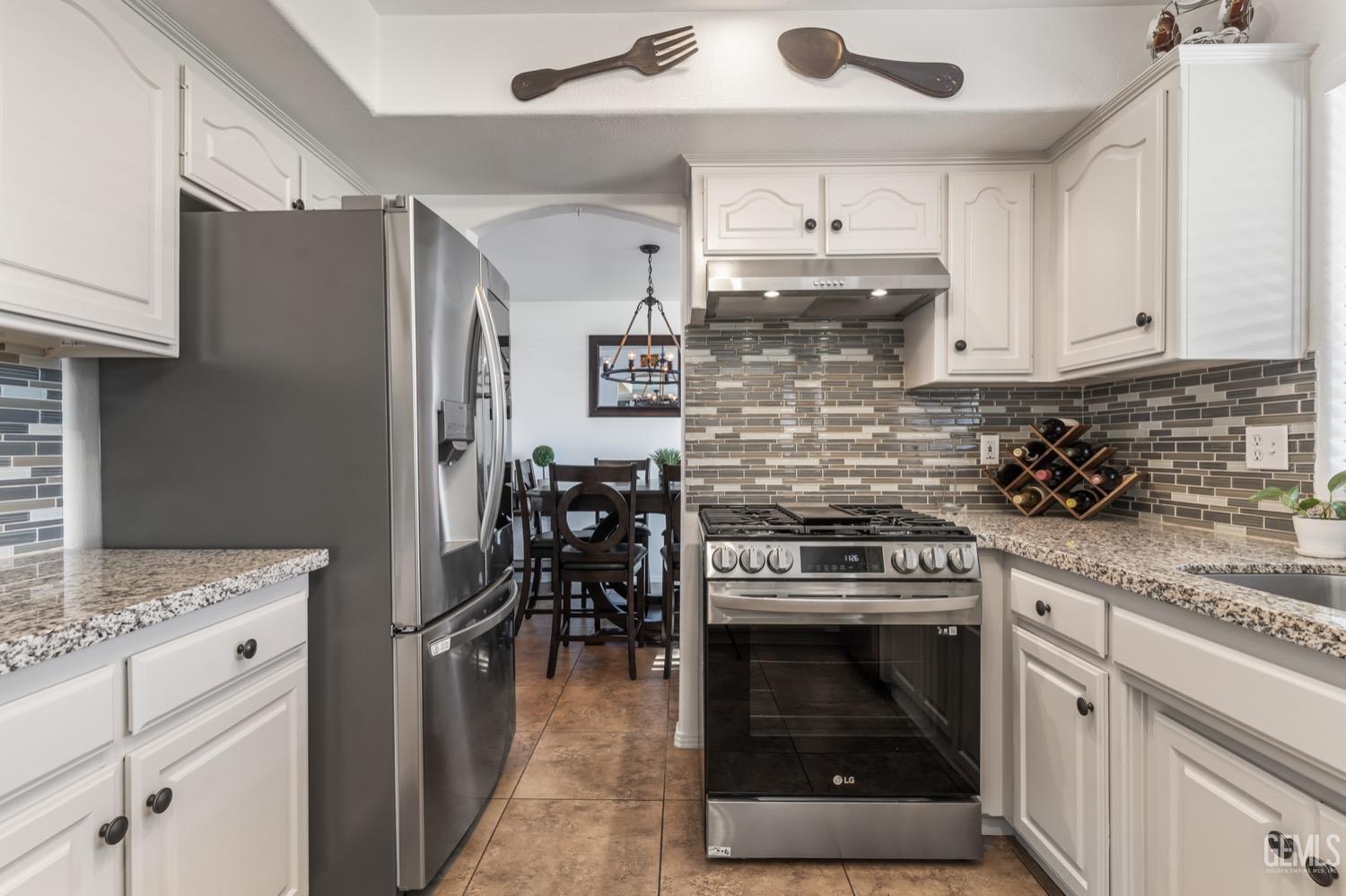 Undisclosed Address Bakersfield, CA 93312 - Photo 8 of 29 a kitchen with granite countertop a stove top oven cabinets and stainless steel appliances