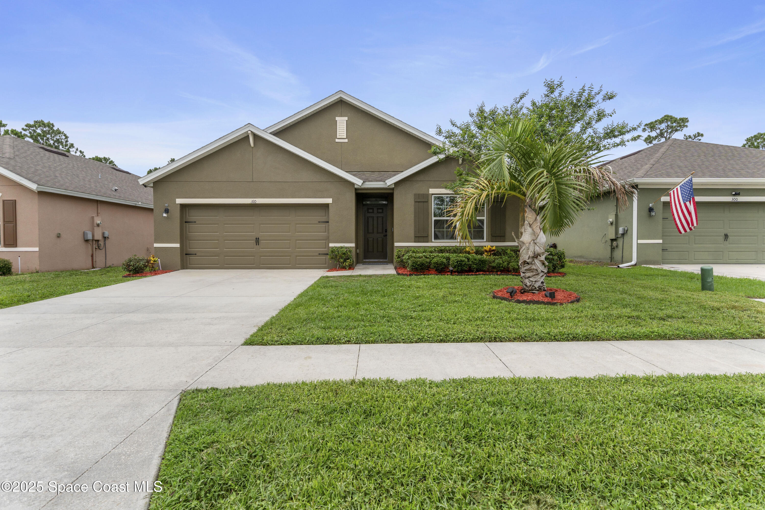 310 Forest Trace Circle Titusville, FL 32780 - Photo 1 of 36 a front view of a house with a yard and garage