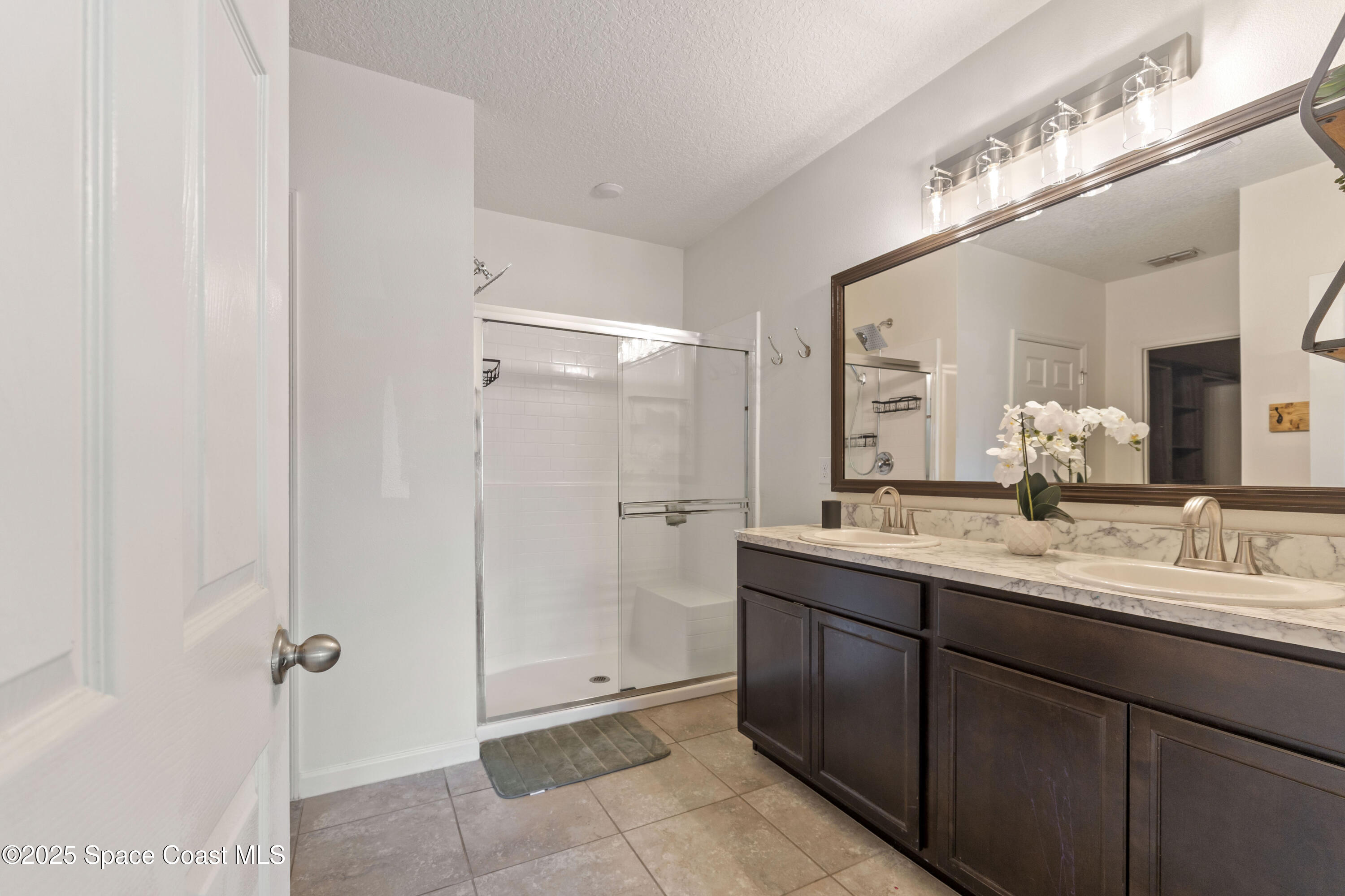 310 Forest Trace Circle Titusville, FL 32780 - Photo 17 of 36 a bathroom with a double vanity sink mirror and shower