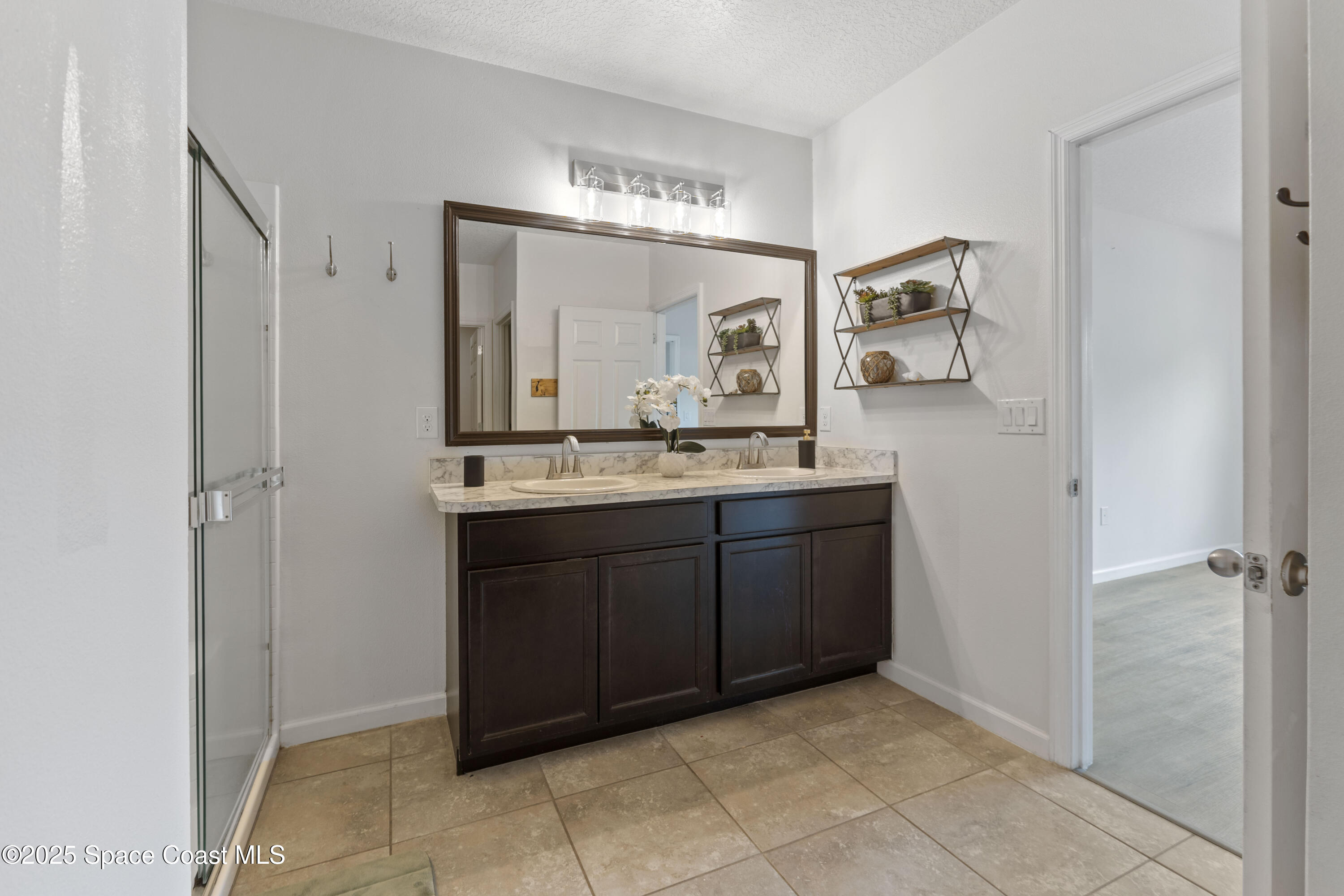 310 Forest Trace Circle Titusville, FL 32780 - Photo 18 of 36 a bathroom with a granite countertop sink a mirror and a vanity
