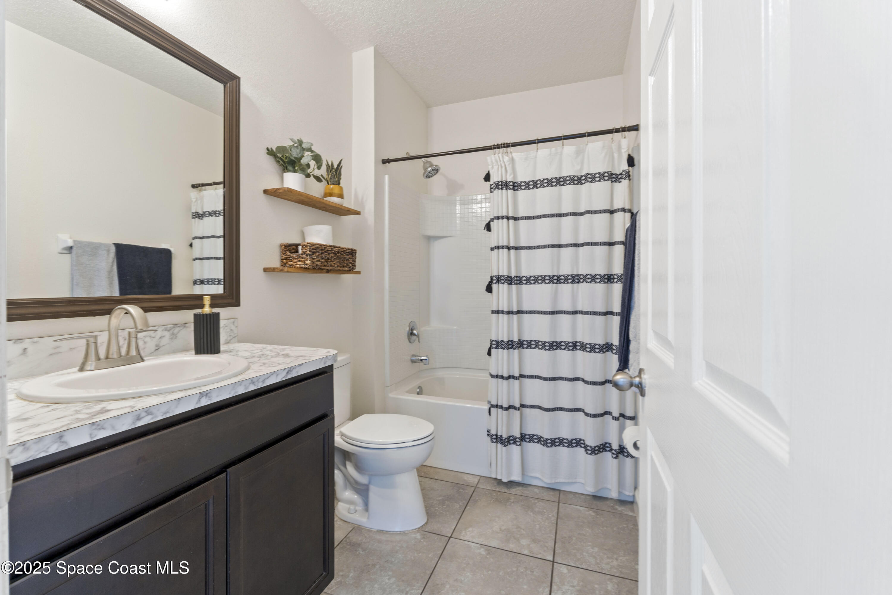 310 Forest Trace Circle Titusville, FL 32780 - Photo 28 of 36 a bathroom with a granite countertop toilet sink and shower
