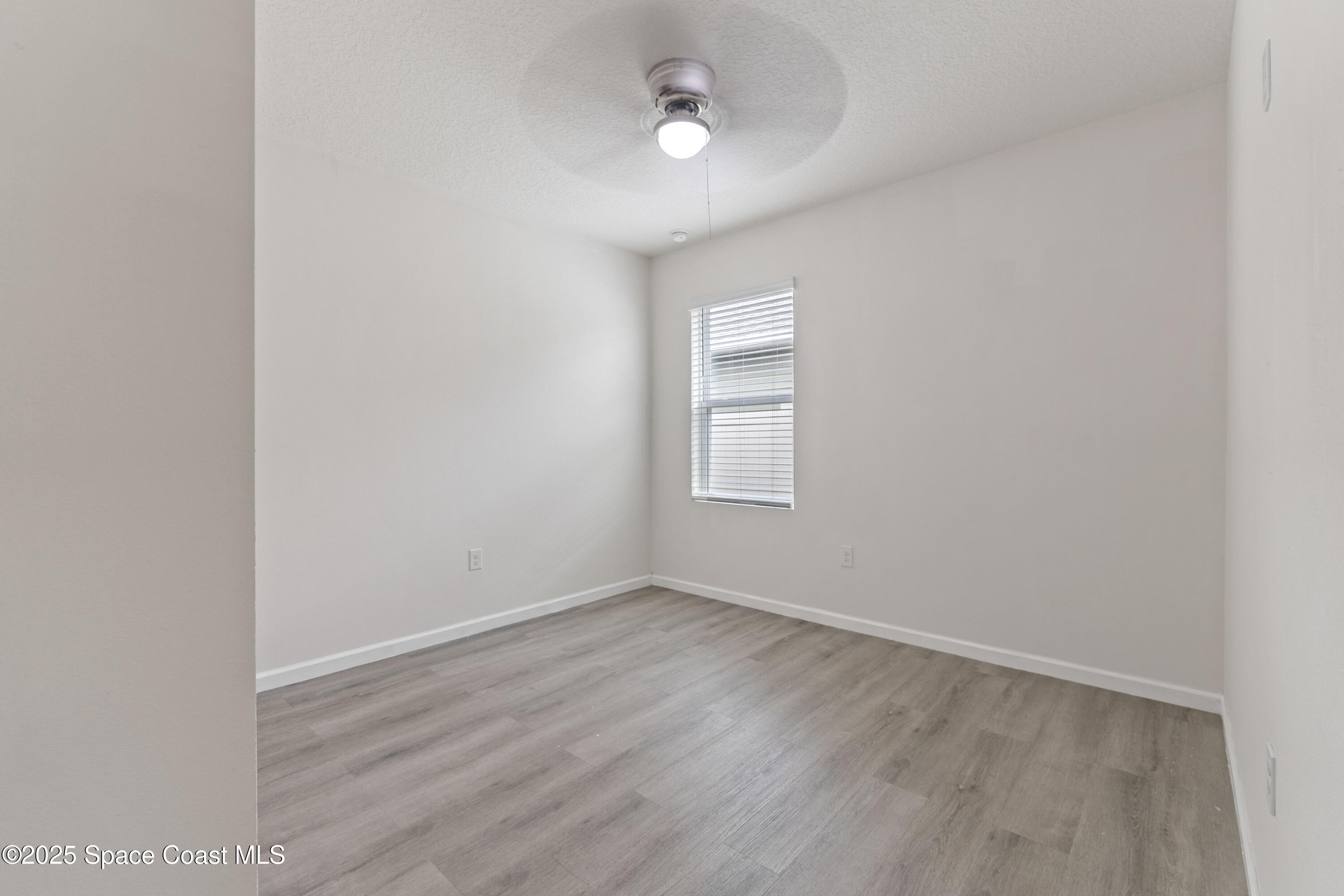 310 Forest Trace Circle Titusville, FL 32780 - Photo 29 of 36 an empty room with wooden floor and windows