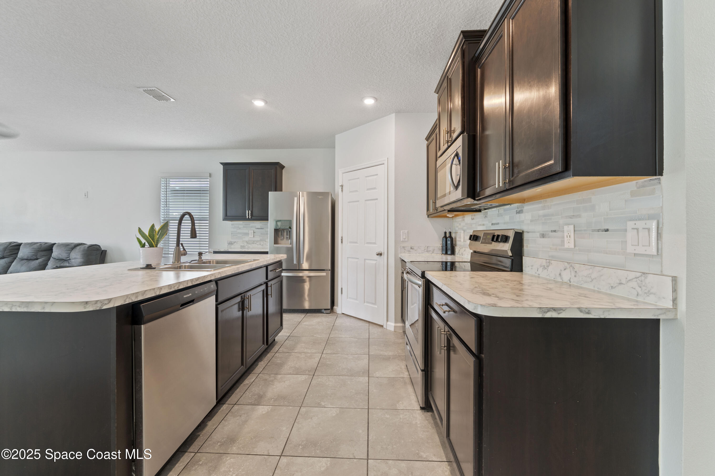 310 Forest Trace Circle Titusville, FL 32780 - Photo 6 of 36 a kitchen with stainless steel appliances granite countertop a sink counter space cabinets and a sink