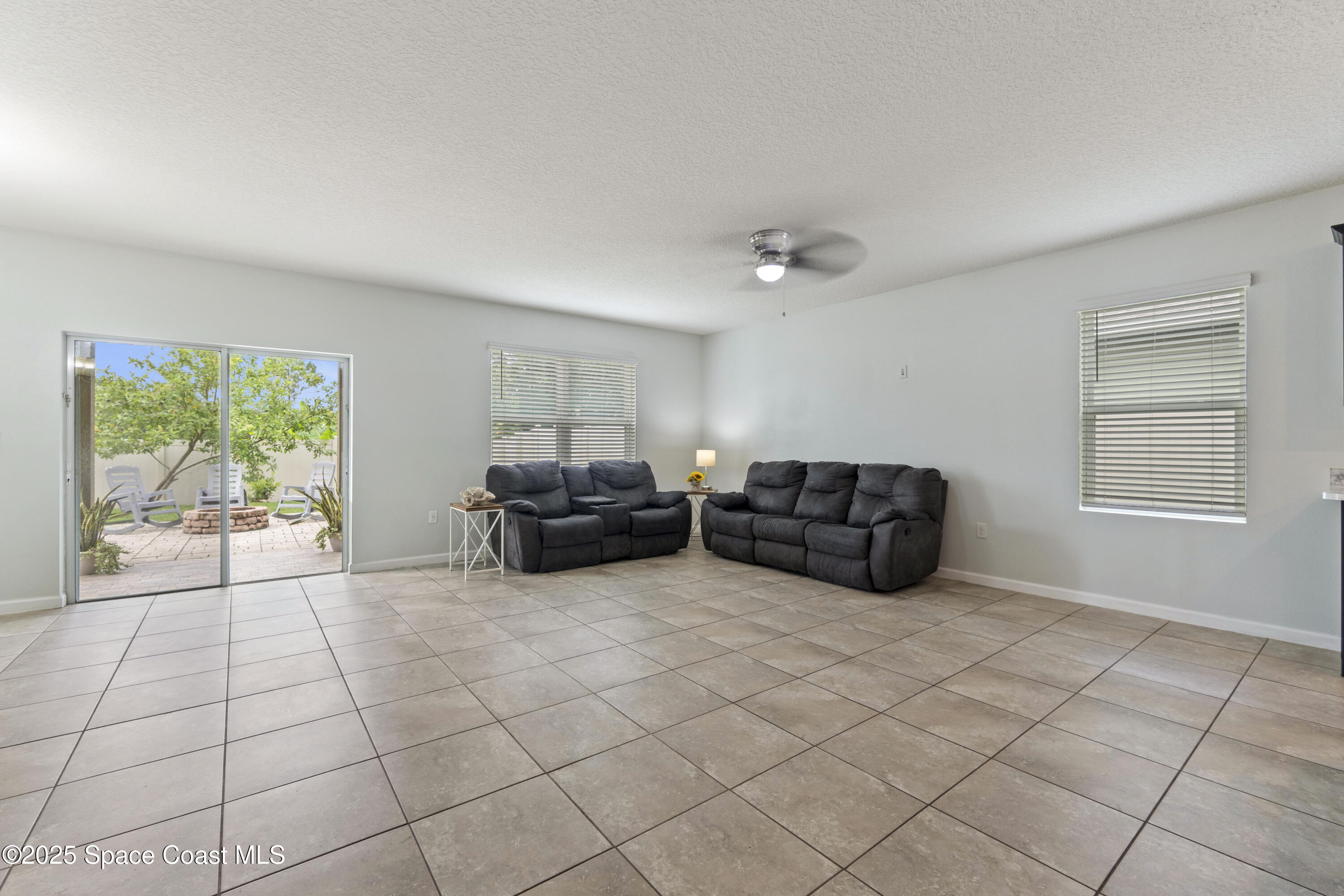 310 Forest Trace Circle Titusville, FL 32780 - Photo 9 of 36 a living room with furniture and a floor to ceiling window