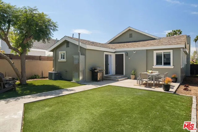a view of a house with a yard and chairs