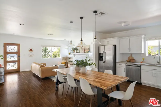 a kitchen with stainless steel appliances kitchen island granite countertop a dining table chairs and granite counter tops