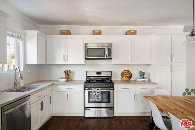 a kitchen with stainless steel appliances a stove a sink and wooden cabinets