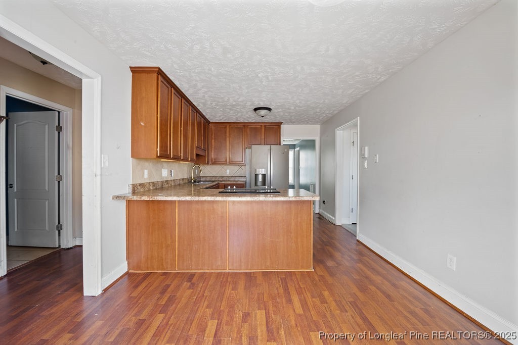 185 Sunflower Street Raeford, NC 28376 - Photo 11 of 30 a kitchen with wooden floors and wooden cabinets