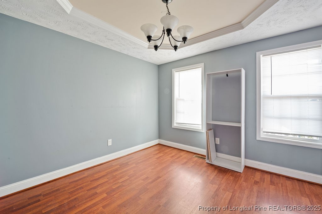 185 Sunflower Street Raeford, NC 28376 - Photo 12 of 30 an empty room with wooden floor chandelier and windows