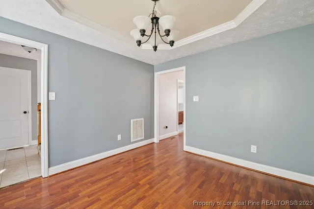 a view of a room with wooden floor and chandelier