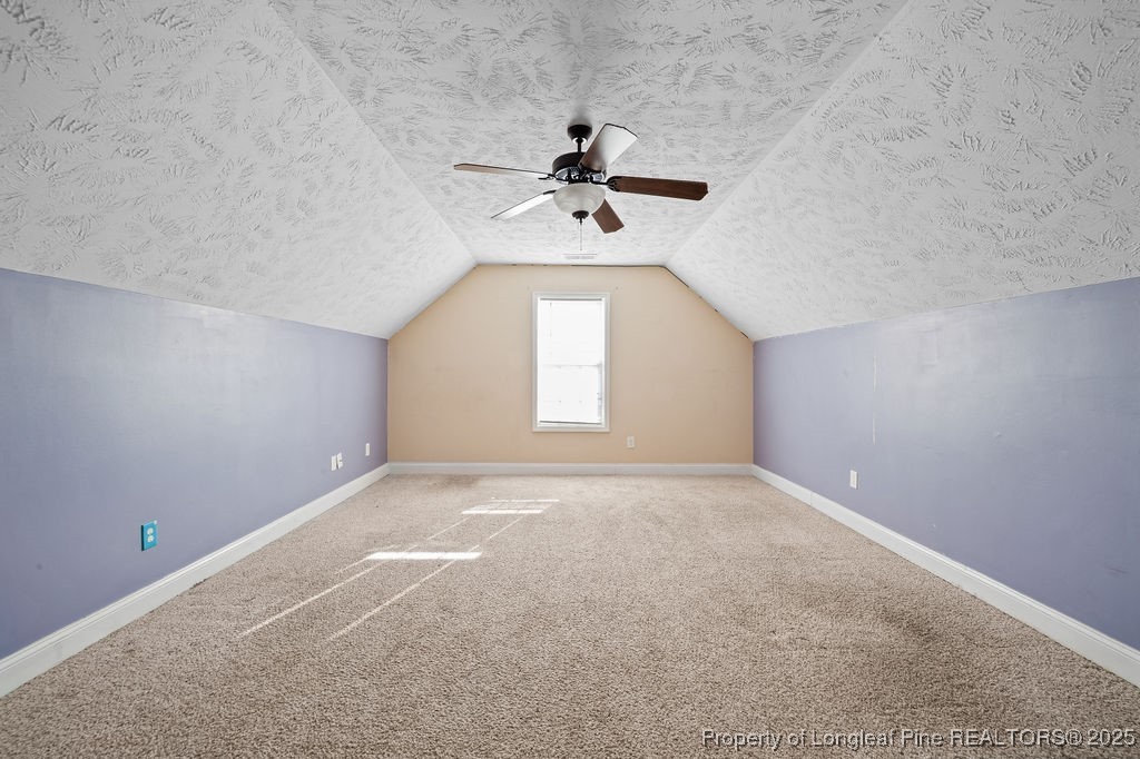 185 Sunflower Street Raeford, NC 28376 - Photo 16 of 30 an empty room with a chandelier fan and windows
