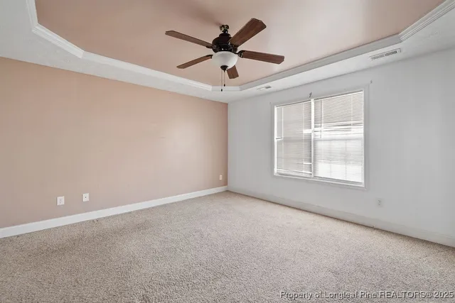 an empty room with ceiling fan and windows