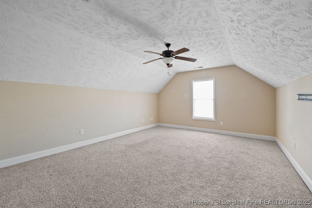 185 Sunflower Street Raeford, NC 28376 - Photo 26 of 30 an empty room with a chandelier fan and windows