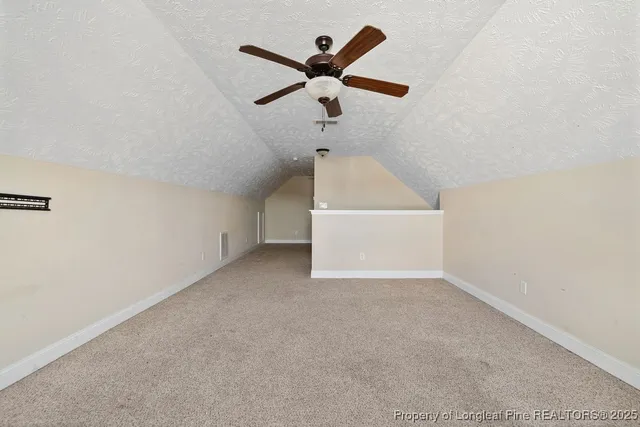 an empty room with ceiling fan and window