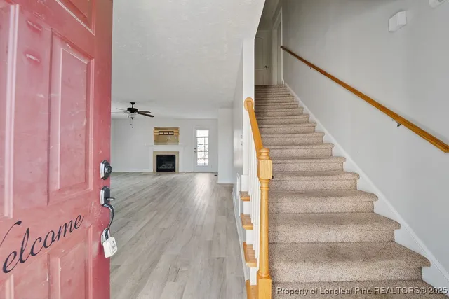 a view of a hallway with wooden floor and staircase