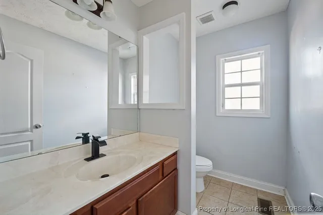 a bathroom with a sink a toilet and a window