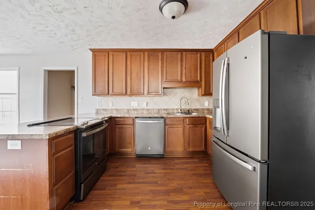 a kitchen with stainless steel appliances granite countertop a refrigerator sink and cabinets