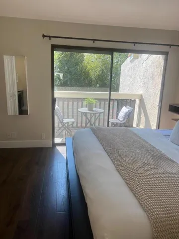 a bed sitting in a bedroom next to a window and a lamp