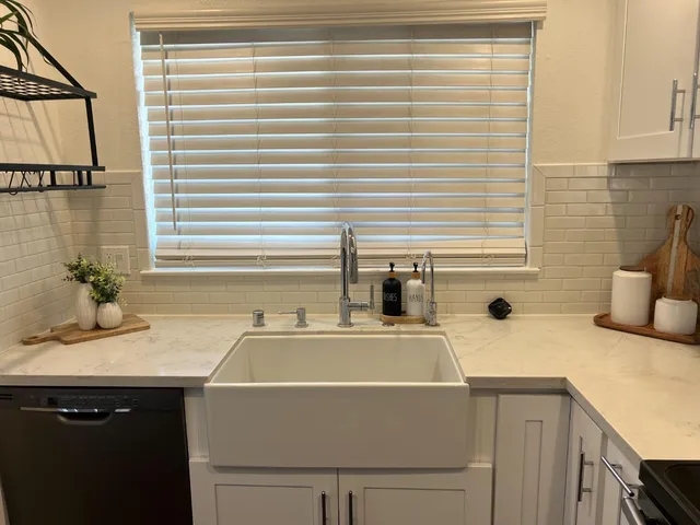 a room with a sink cabinets and a window