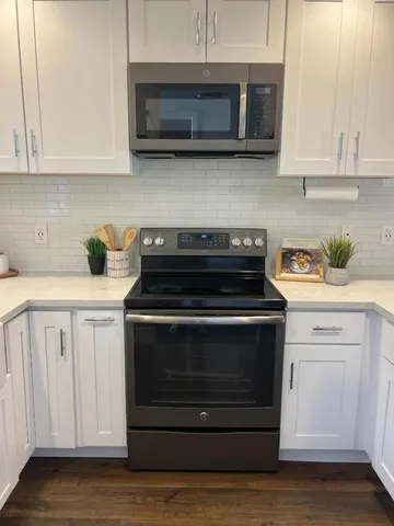 a kitchen with white cabinets and stainless steel appliances