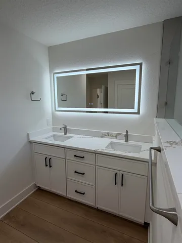 a bathroom with a sink and two mirror