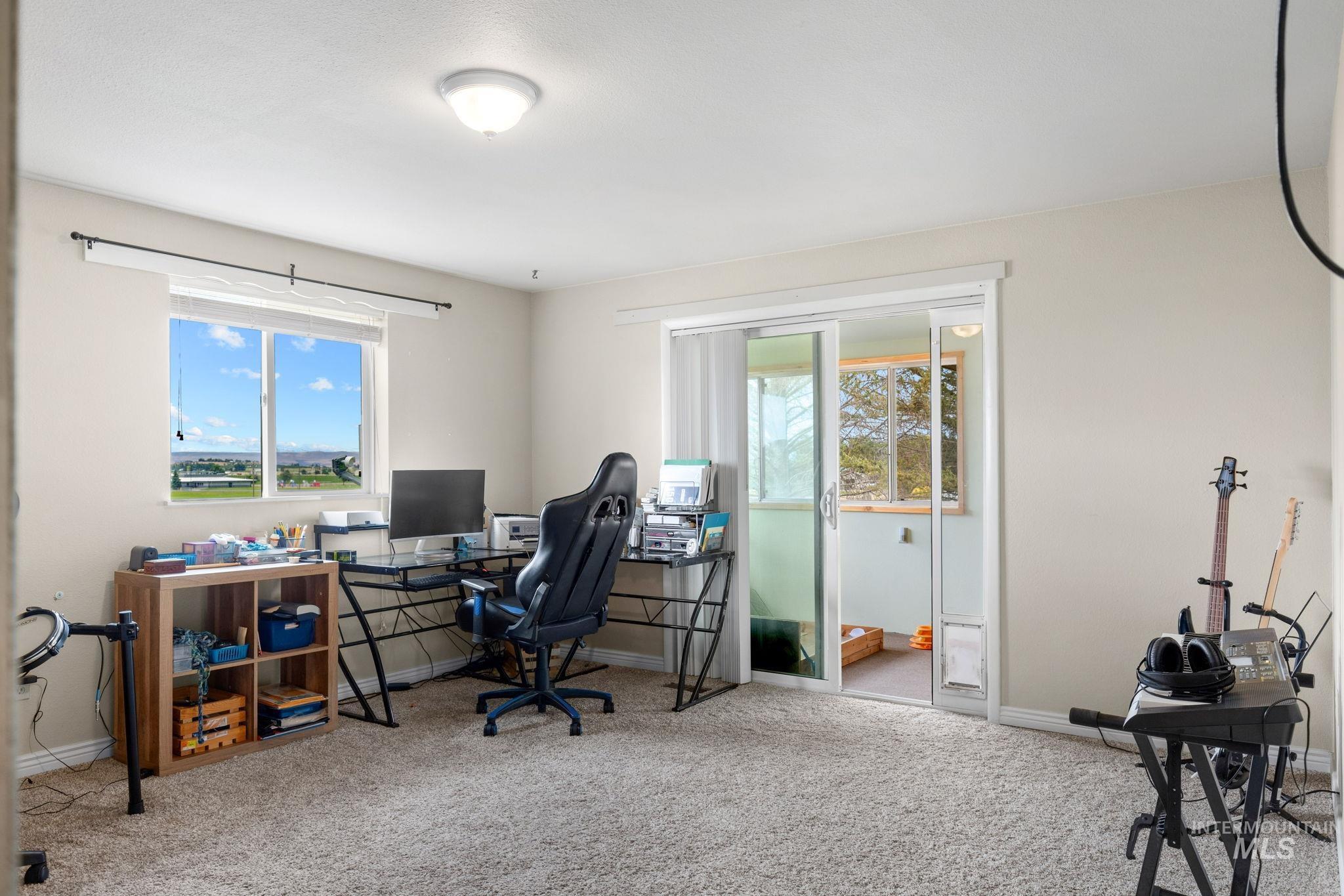 18338 Pride Lane Caldwell, ID 83607 - Photo 28 of 50 Carpeted room featuring a large window with a distant landscape, a flush-mount ceiling light, and sliding glass doors opening to an exterior space