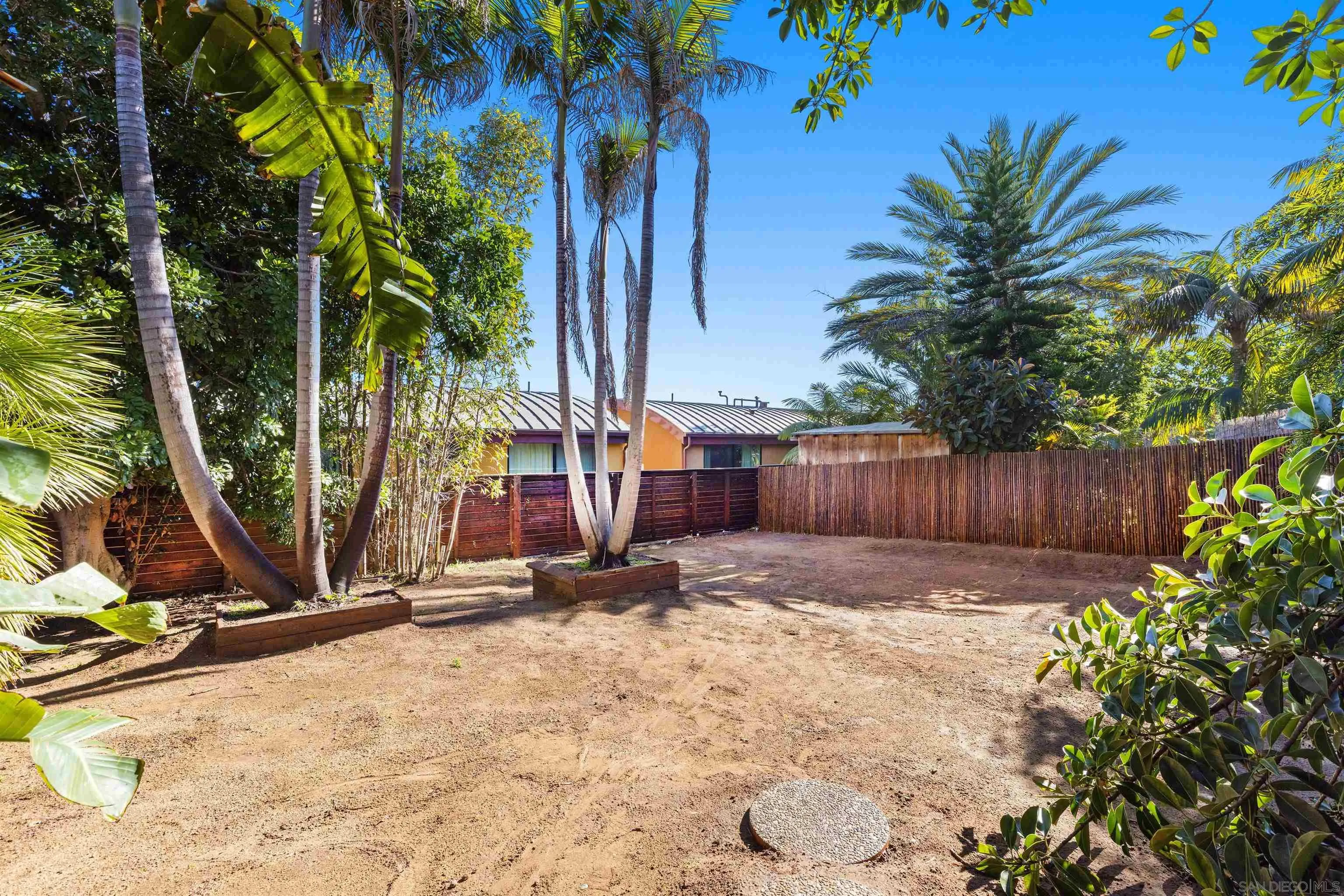 843 Neptune Avenue Encinitas, CA 92024 - Photo 36 of 49 a view of backyard with wooden fence and a large tree