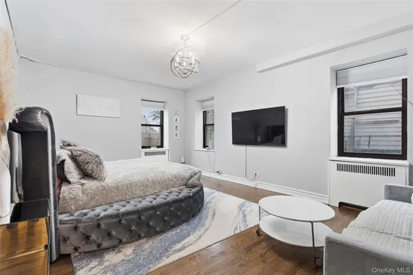 a living room with furniture a flat screen tv and a window
