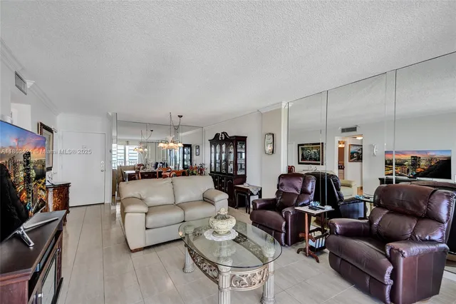 a living room with furniture a flat screen tv and a large window