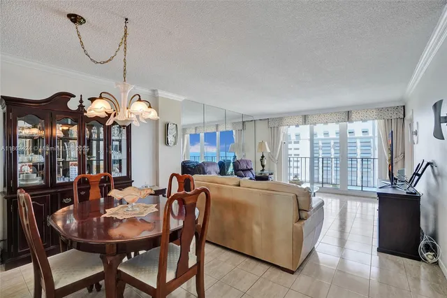 a view of a dining room with furniture a chandelier and wooden floor