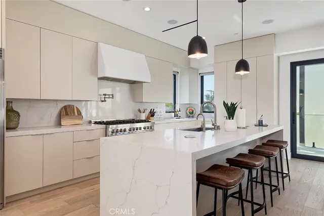 a kitchen with stainless steel appliances granite countertop a sink a stove a refrigerator and cabinets