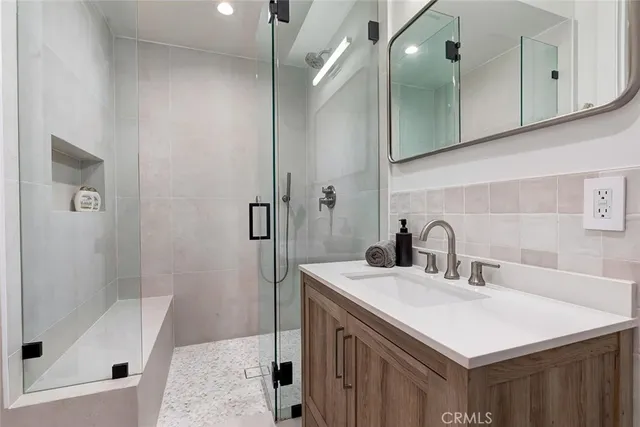 a bathroom with a sink a toilet a shower and a mirror