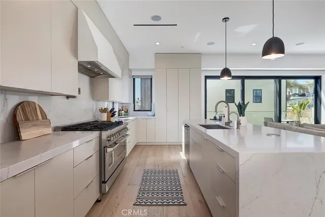 a kitchen with stainless steel appliances granite countertop a sink a stove and a wooden floors